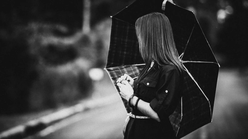 Retrato de uma mulher com guarda-chuva, olhado para trás.