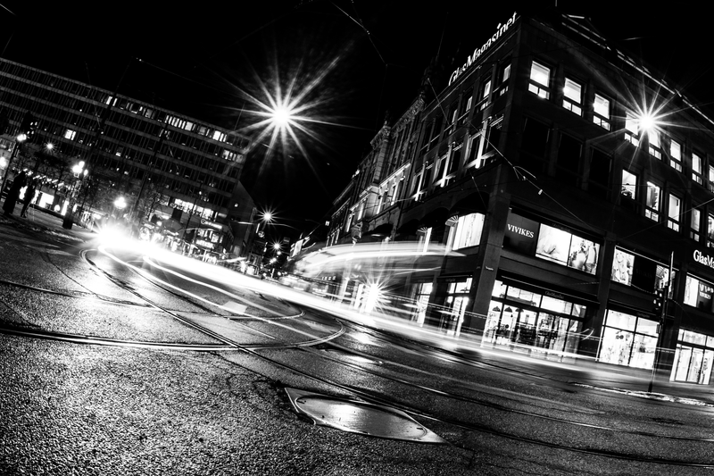 Imagem de um cruzamento de rua com luzes indicando a passagem de carros.