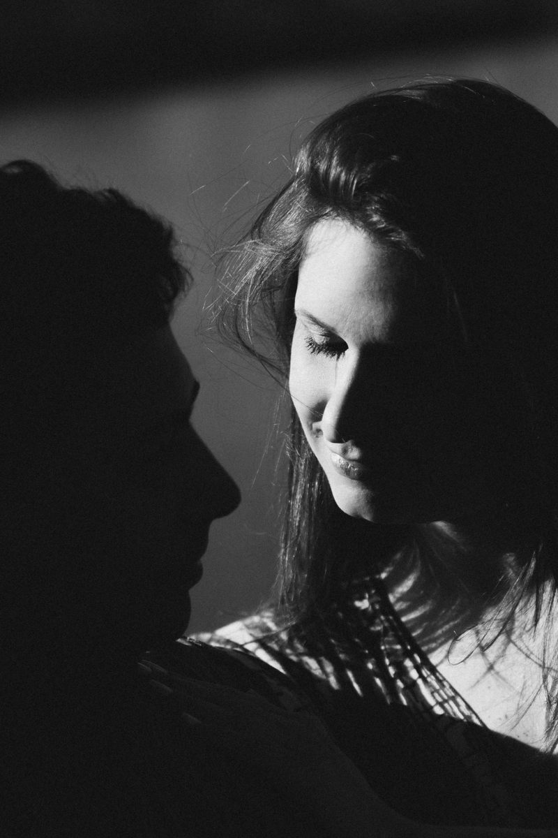 Retrato de um homem e uma mulher. Dele se vê a silhueta, e metade do rosto dela está bastante iluminado.