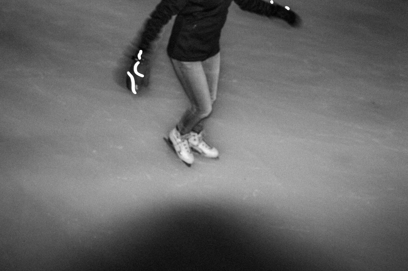 Foto de pessoa patinando no gelo, em que se vê uma mancha escura arredondada na parte inferior.