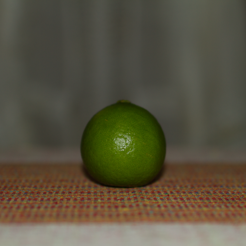 A foto de um limão verde iluminado frontalmente.