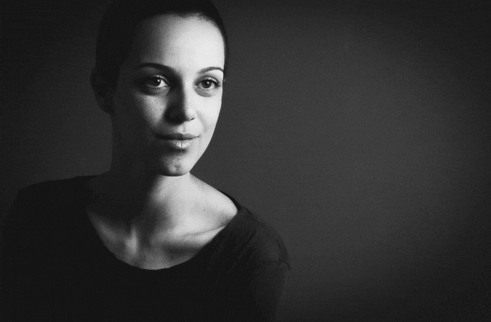 Retrato de mulher com luz lateral fazendo um triângulo de luz na bochecha direita.