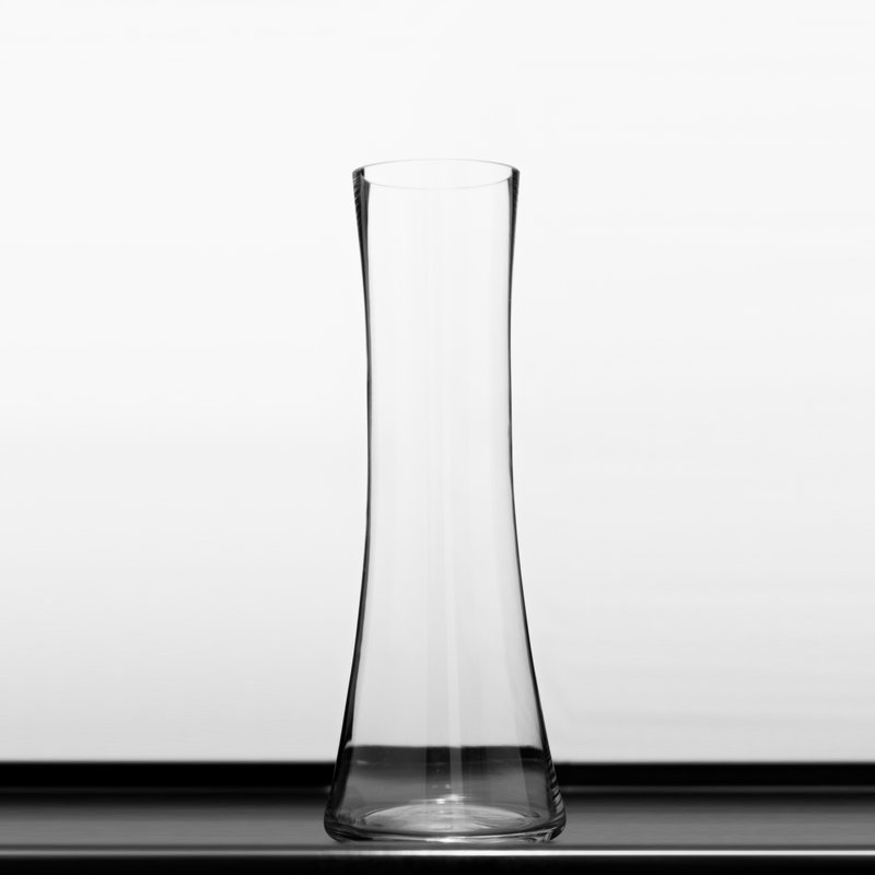 Foto de um vaso de vidro com o fundo branco e reflexos pretos no entorno do objeto.