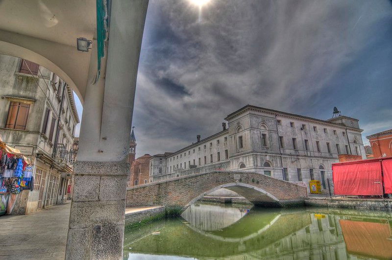 Imagem de canal, ponte e prédio com pouco contraste.