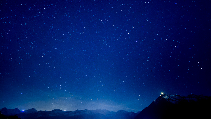 Foto do céu com estrelas sem rastros e montanhas.